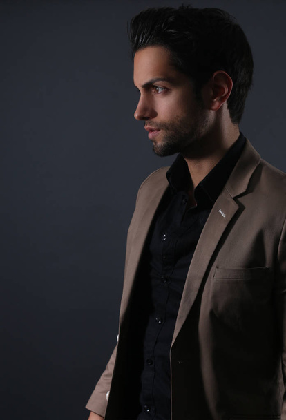 handsome man in a business suit on a dark background - Photo, Image
