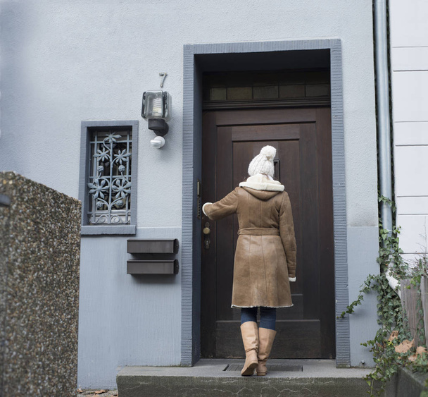 Una joven está dispuesta a irse a casa. En la puerta principal fuera de una casa
  - Foto, imagen