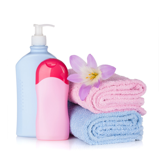 Bottiglie di shampoo e gel con asciugamani e fiori
 - Foto, immagini