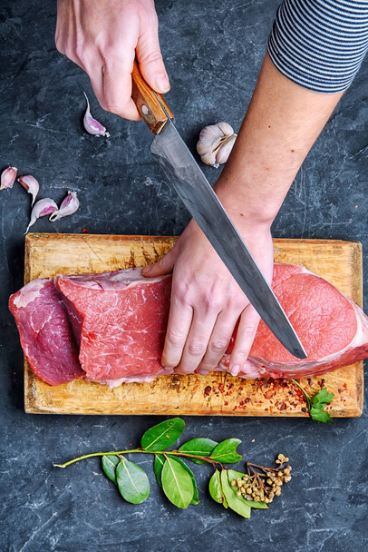 La mujer en la cocina está cortando carne
 - Foto, Imagen