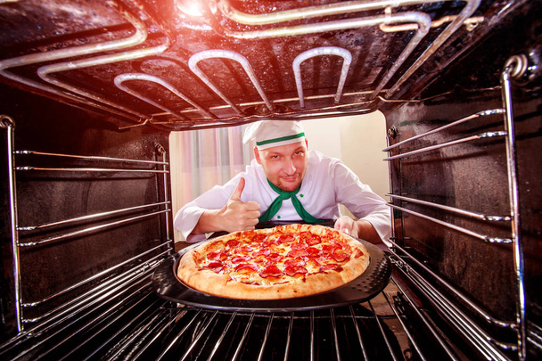 kuchař vaření pizza v peci. - Fotografie, Obrázek