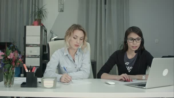 Two women working together in the office - Materiał filmowy, wideo