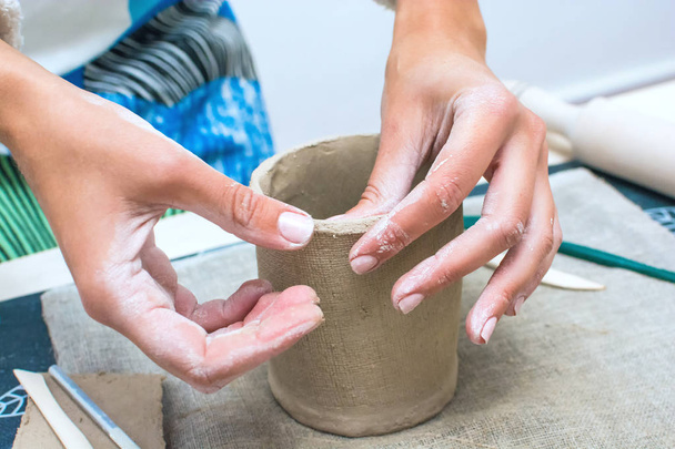 Warsztaty ceramiki. Kobieta ręce zbliżenie Dokonywanie garnek z gliny surowe - Zdjęcie, obraz