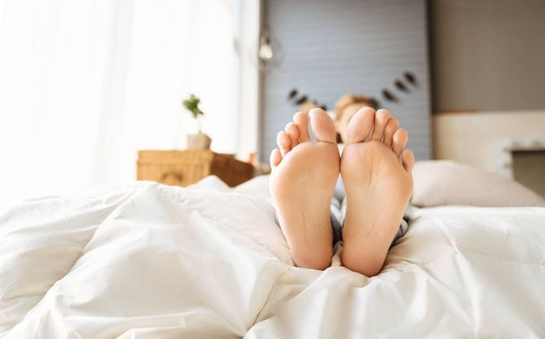 Close up de mulheres grávidas pés deitados na cama
 - Foto, Imagem