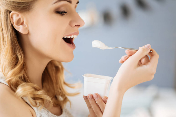 Portrait of pregnant woman eating yoghurt - Foto, imagen