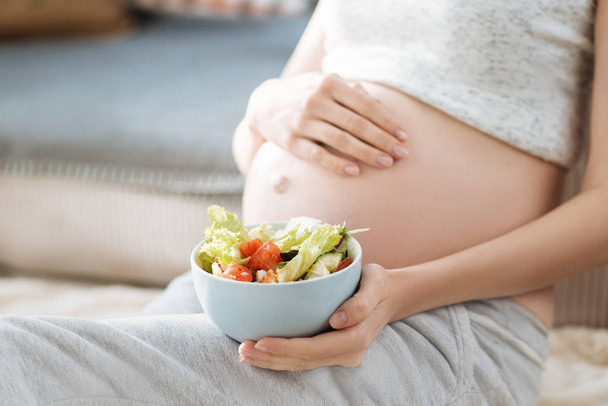 Close up of pregnant woman holding a salad - Foto, Bild