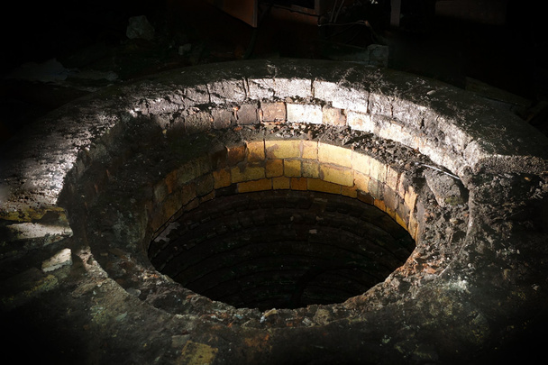 Ominous brick well with mysterious lighting - Photo, Image