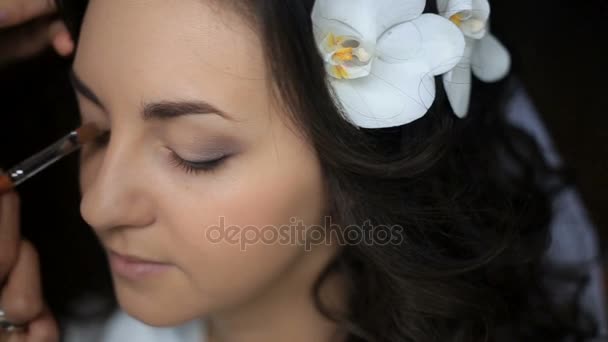 Kobieta makijaż dla panny młodej z Biała orchidea w jej czarne włosy - Materiał filmowy, wideo