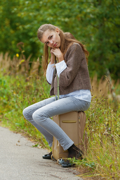 triste belle jeune femme assise sur la valise de route
 - Photo, image