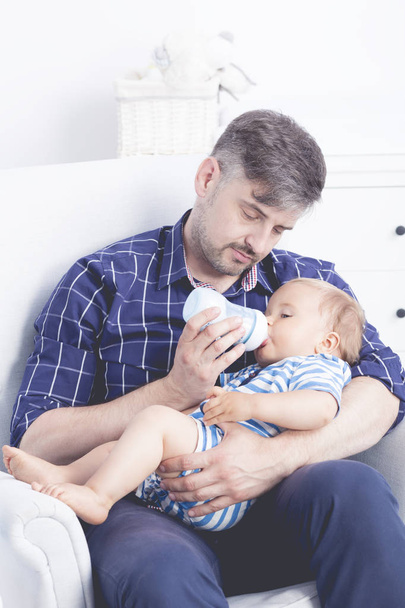Father feeding baby with bottle - Foto, afbeelding