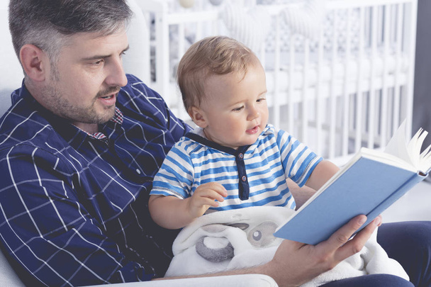 Padre con bebé leyendo un libro
 - Foto, imagen
