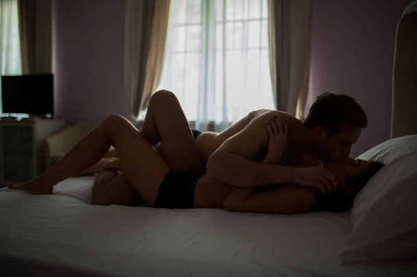 若いカップルがキスをし、横になっています。. - 写真・画像