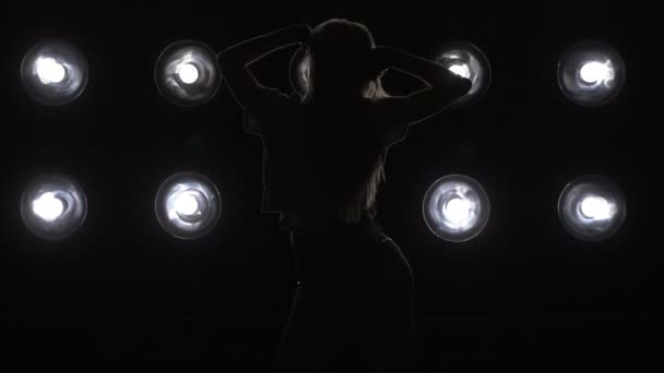 Silhouette eines Mädchens, das auf dem Hintergrundlicht tanzt. Zeitlupe - Filmmaterial, Video