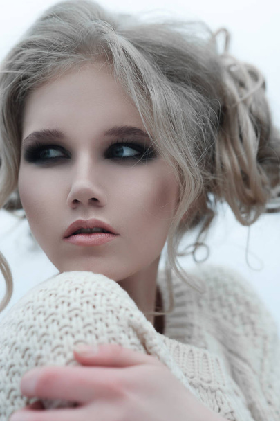 Close up of beautiful young  blonde woman with blue eyes in white pullover. - 写真・画像
