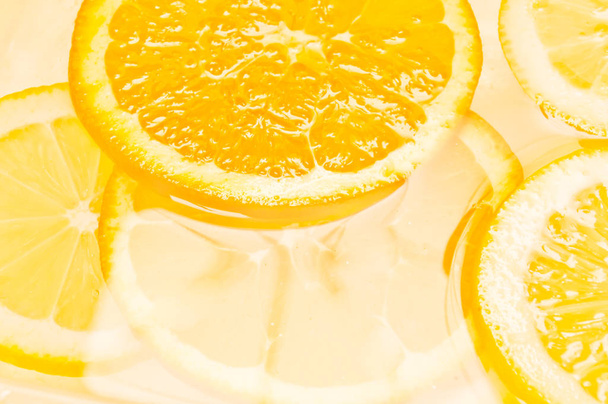 Orange and lemon citrus fruits slices in water - Fotoğraf, Görsel