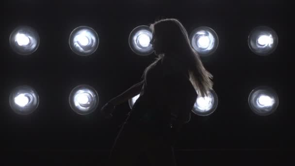Silhouette eines Mädchens, das auf dem Hintergrundlicht tanzt. Zeitlupe - Filmmaterial, Video
