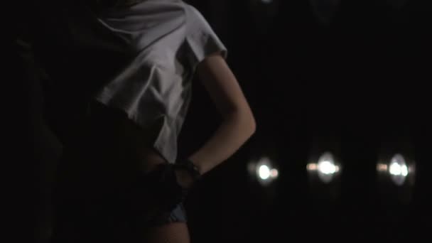 Silhouette of a girl dancing on the background lights. Slow motion - Footage, Video