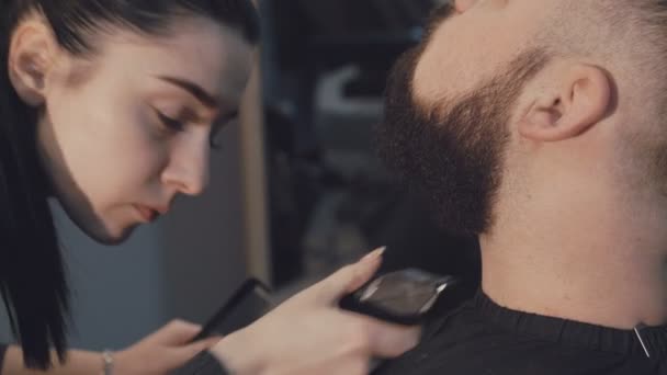 Female barber cuts the beard hair of the male client 4K - Filmati, video