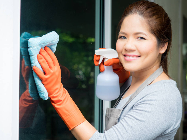 asiático dona de casa limpeza na janela de vidro
 - Foto, Imagem