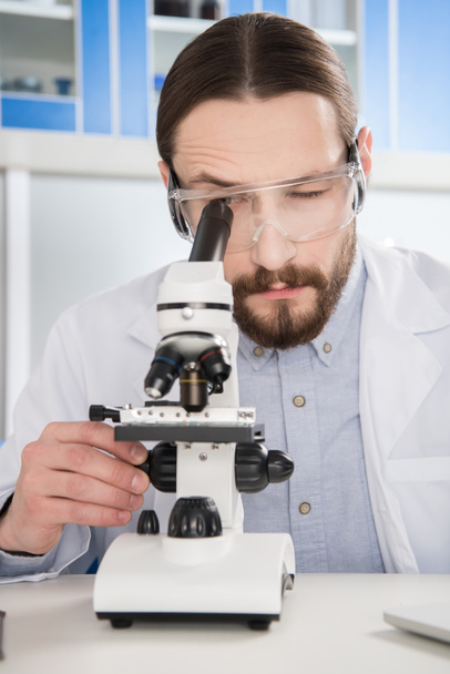 Man looking in microscope - Photo, Image