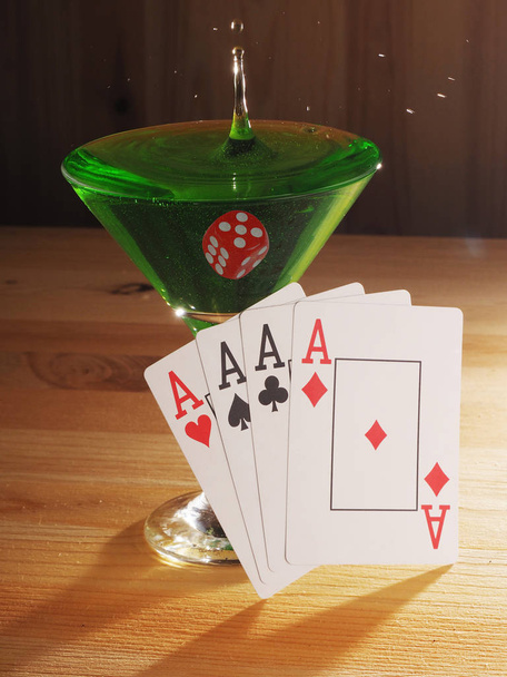 Glass with a cocktail and playing cards . wooden background - Zdjęcie, obraz