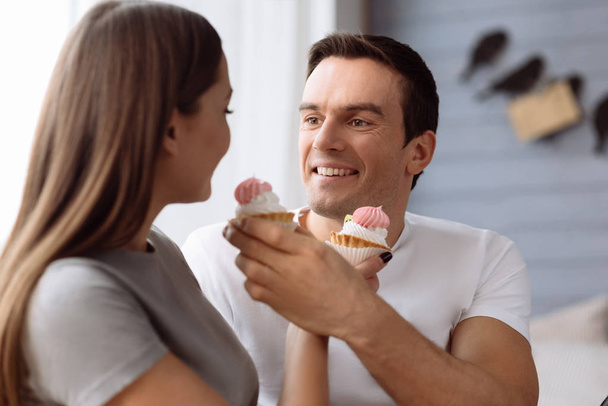 Веселий позитивний чоловік годує свою дівчину
 - Фото, зображення