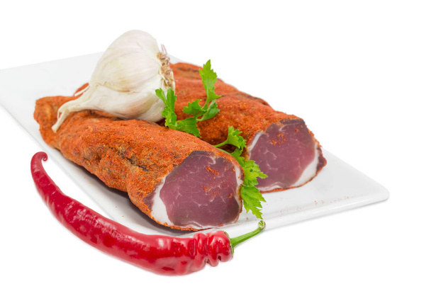 Gedroogde varkensvlees varkenshaas, knoflook, chili en peterselie closeup - Foto, afbeelding