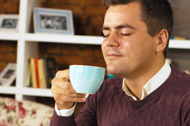 Mladý muž pít kávu, čaj nebo čokoláda - Fotografie, Obrázek