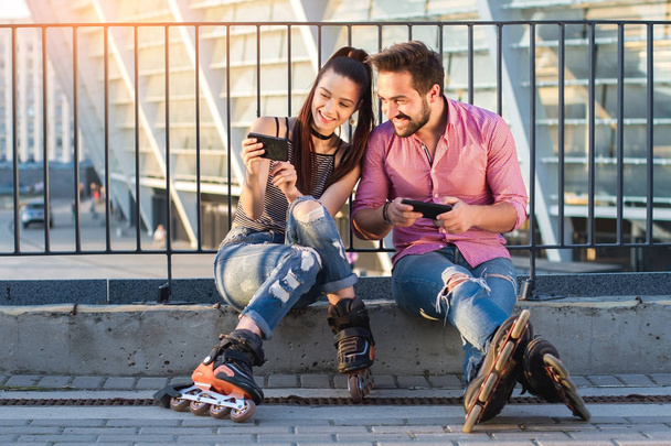 Усміхнена пара тримає мобільні телефони
. - Фото, зображення