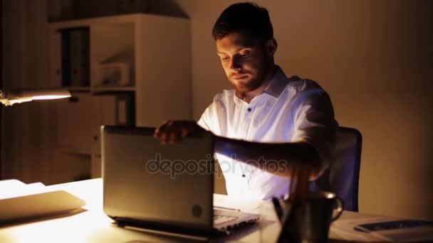 man with laptop finishing work at night office - Imágenes, Vídeo