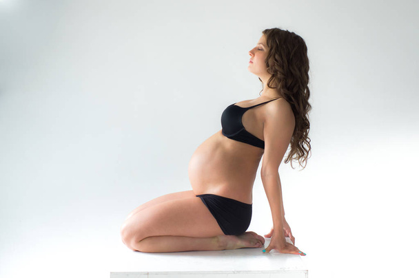 Sitting pregnant woman with closed eyes - Zdjęcie, obraz