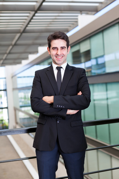 Porträt eines lächelnden jungen Geschäftsmannes im modernen Büro - Foto, Bild