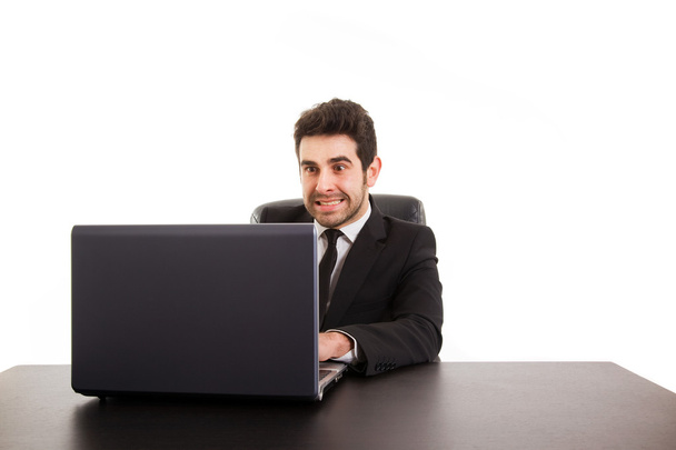 Young business man with laptop at office desk, isolated in white - Foto, immagini