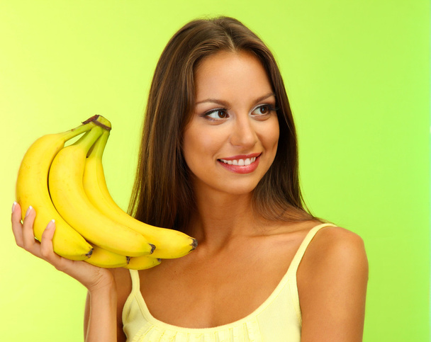 beautiful young woman with bananas, on green background - Photo, image