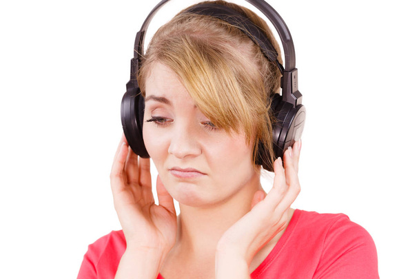 Woman sad girl in big headphones listening music - Фото, изображение