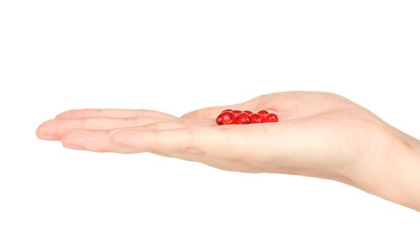 Woman's hand holding a red pill on white background close-up - Fotó, kép
