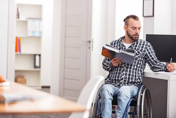 Smart disabled guy spending his free time studying - Foto, Imagen