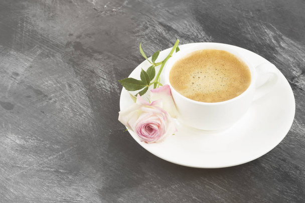 Espresso coffee in a white cup and a pink rose on a dark background. Copy space. Food background. Toning. - Foto, imagen
