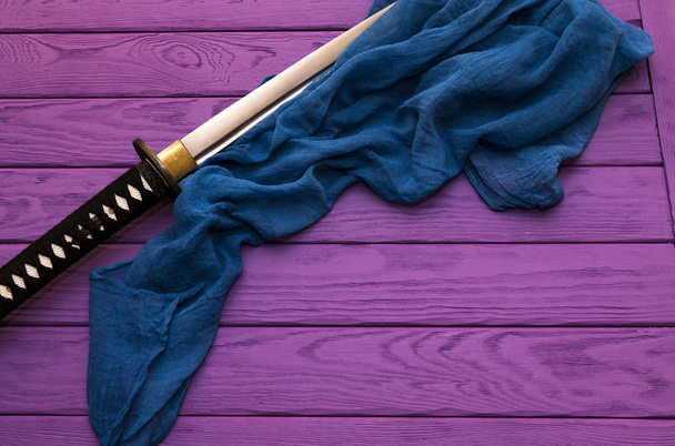 Ιαπωνία katana σπαθί στο μοβ φόντο ξύλου  - Φωτογραφία, εικόνα