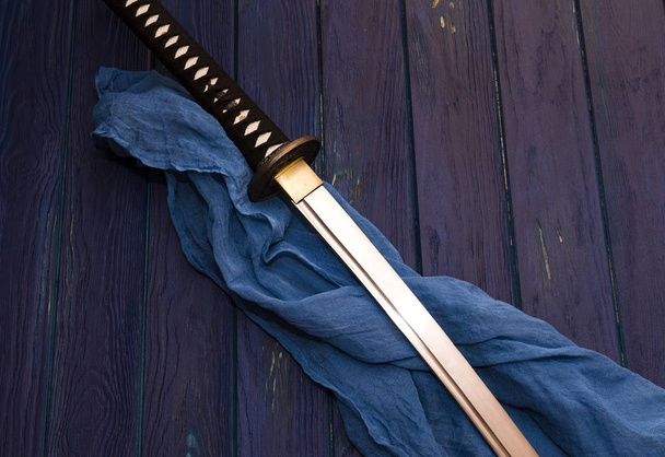 japan katana schwert auf dem holzhintergrund mit dem blauen schal - Foto, Bild