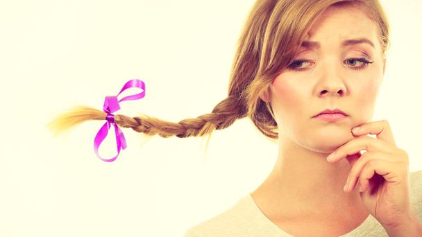 Teenage girl in braid hair making thinking face - Фото, изображение