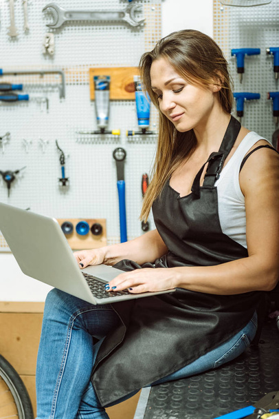 Involved female mechanic surfing the Internet in the workshop - Photo, image