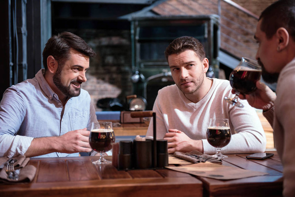 Cheerful male friends sitting at the table - Foto, immagini