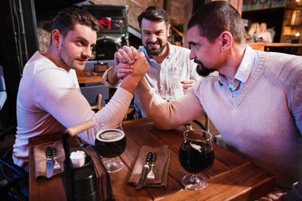 Good looking male friends armwrestling - Фото, изображение