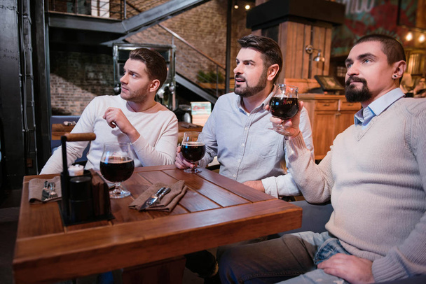 Serious pleasant men spending time in the pub - Fotó, kép