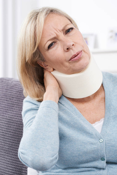 Femme mature portant un collier chirurgical dans la douleur
 - Photo, image