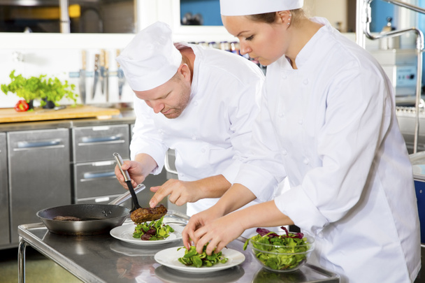 Dos chefs preparan un plato de carne en el restaurante gourmet
 - Foto, imagen