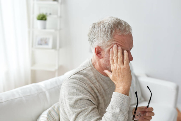 senior man suffering from headache at home - Foto, Bild