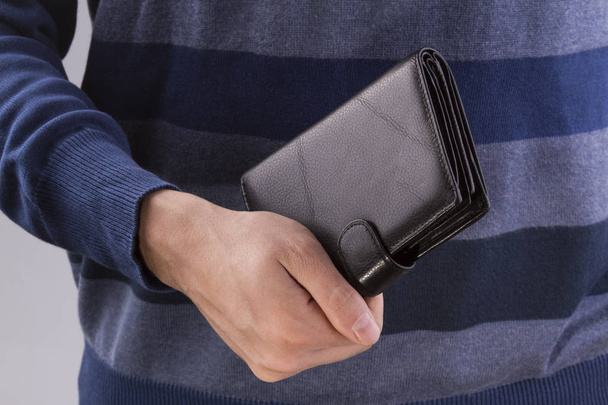homem segurando uma carteira fechada
 - Foto, Imagem