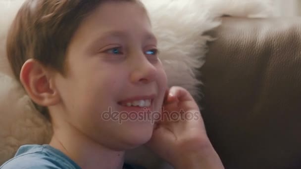 Happy young boy watching TV at home and laughing - Footage, Video